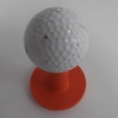 orange golf tee and ball